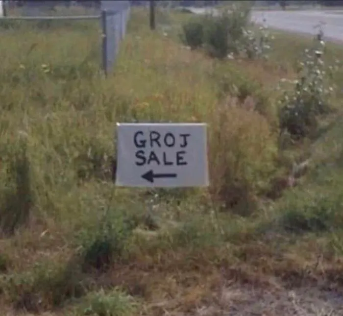 A homemade yard sign reading GROJ SALE, an example of a funny spelling fail