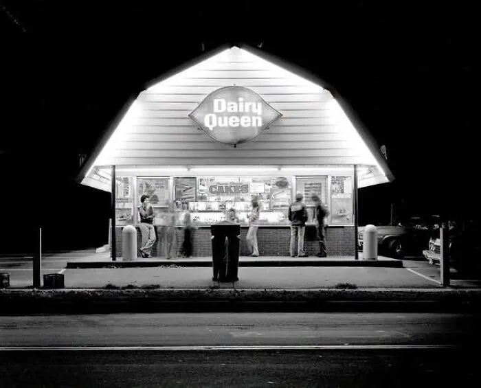 Black and white photograph of an illuminated vintage Dairy Queen building, capturing old photos of America.