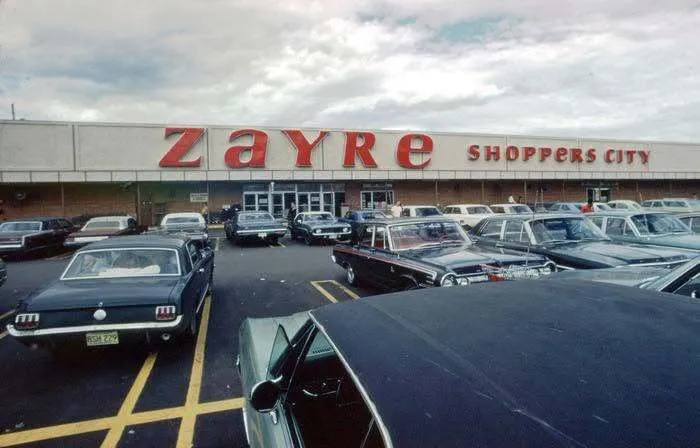 Old photo of a Zayre Shoppers City store parking lot with classic cars in America