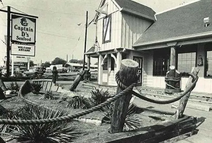 A black and white old photo of America showing the exterior of a vintage Captain D's Seafood restaurant.