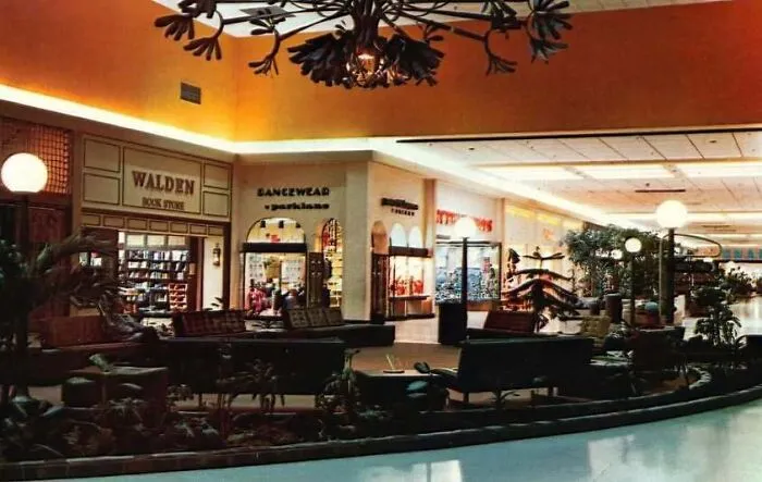An interior view of a 1970s shopping mall concourse with storefronts as seen in old photos of America.