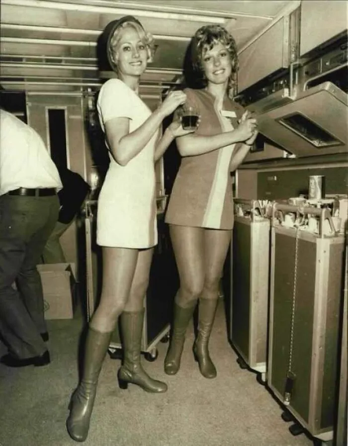 Flight attendants posing inside an airplane gallery in old photos of America.