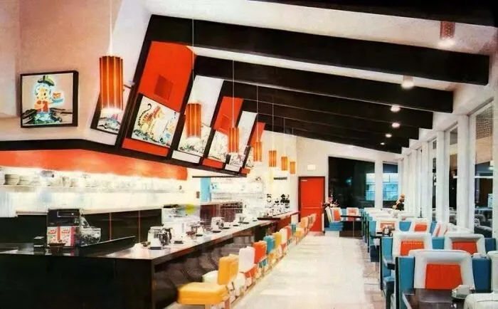 Retro diner interior featuring mid-century modern seating and vibrant orange light fixtures in old photos of America.