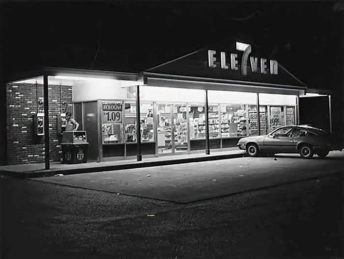 Exterior view of a 7-Eleven store at night in old photos of America
