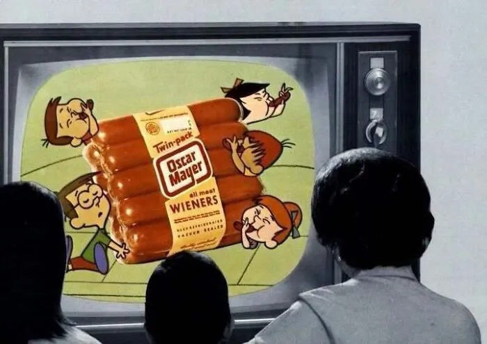 Family watching an Oscar Mayer wiener commercial on television in an old photo of America