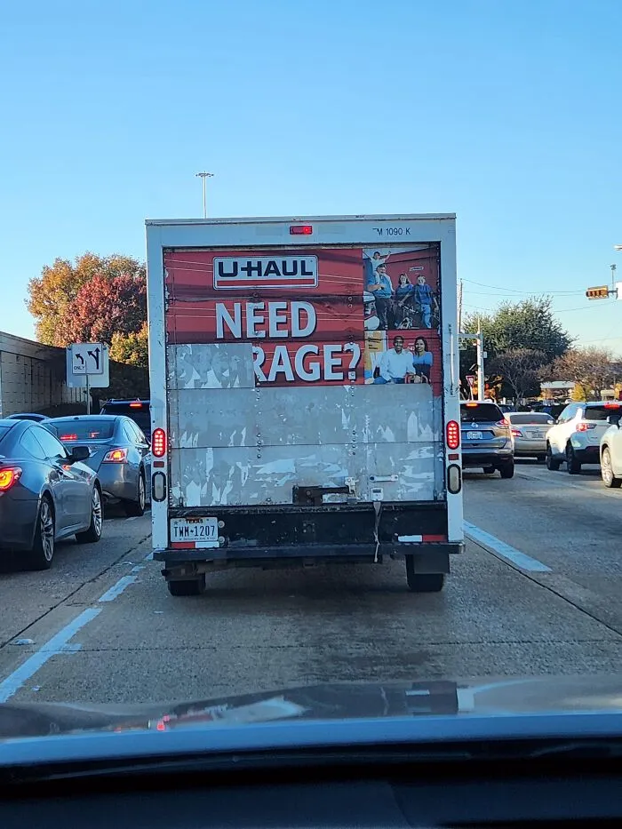 Rear of a U-Haul truck with worn graphic reading NEED RAGE?, showing how truckers turn vehicles into moving jokes