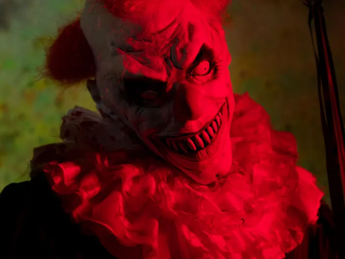 A terrifying evil clown bathed in red light, inspired by scary Halloween stories.