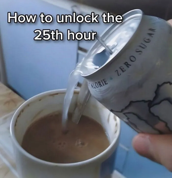 Hand pouring energy drink into a mug of coffee, reflecting hilarious memes about daily struggles.