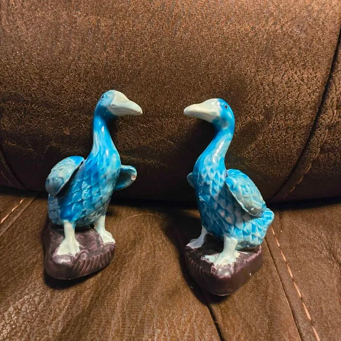 Pair of blue ceramic bird figurines thrift store find on brown surface