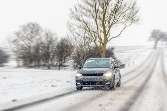 Car driving down a snowy winter road, related to personal divorce stories and cold breakups.