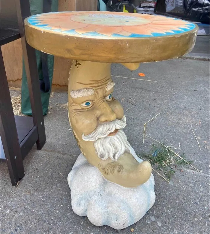 A unique crescent moon face side table discovered as one of the best thrift finds.