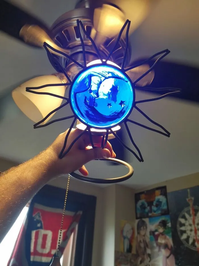 Sun-shaped ceiling fan pull with blue stained glass, a clever thrift find.