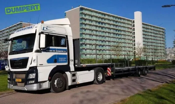 A perfectly confusing photo of a white truck lined up with a building creating an optical illusion.