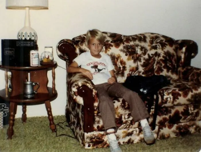 80s child sitting on floral couch vintage living room