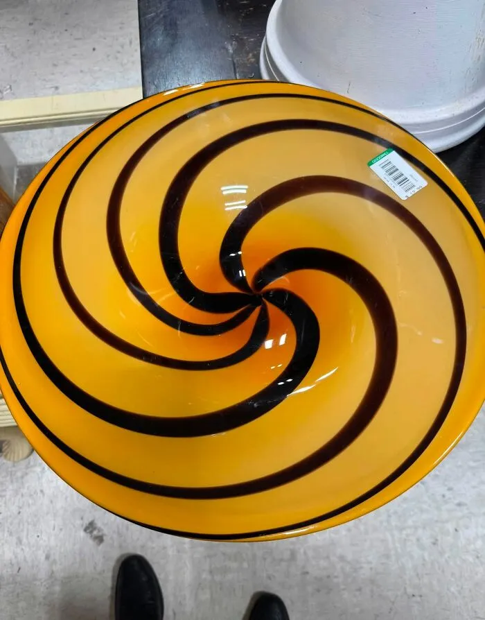 A vibrant yellow and black swirl glass bowl discovered as a unique thrift find.