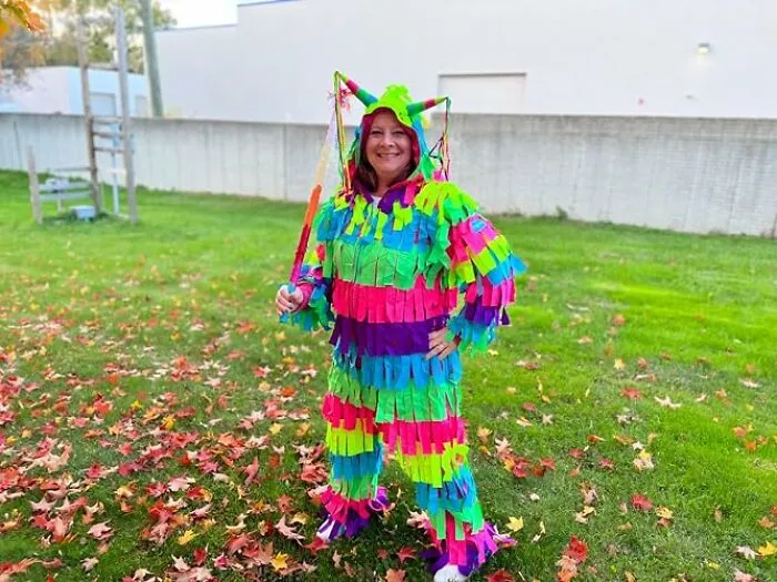 A person standing outdoors in a colorful piñata suit as a fun low-effort Halloween costume.