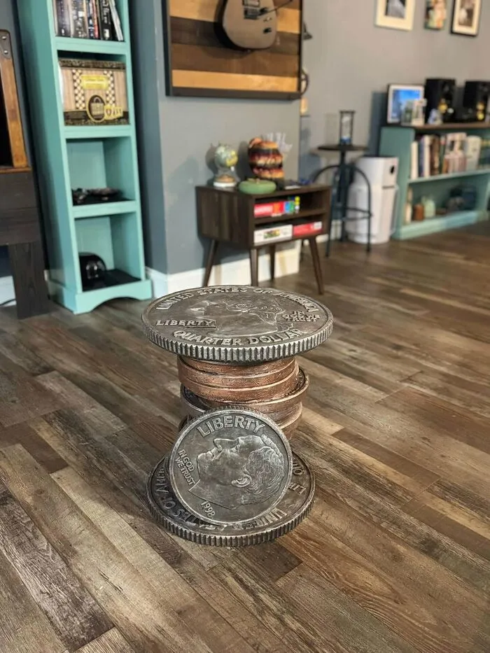 Novelty coin-shaped side table stacked like giant quarters, a weird thrift find in a living room