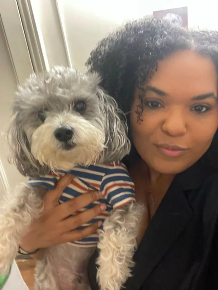 A woman and her curly-haired dog pose together, demonstrating how pets looked so much like their owners