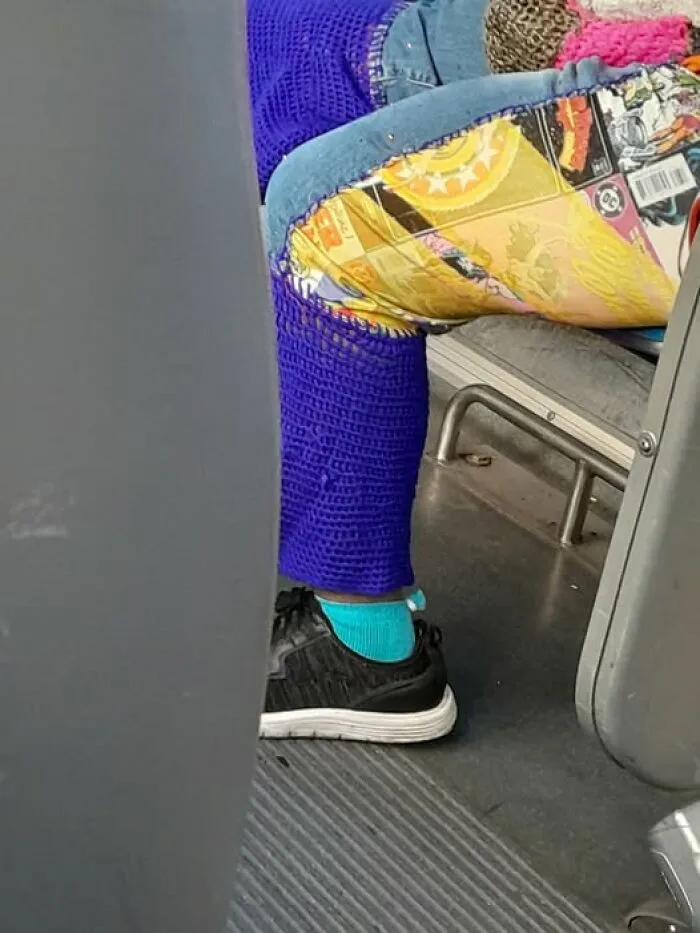 A person wearing pants made of denim, comic book print, and bright blue crochet as hilarious crafts.