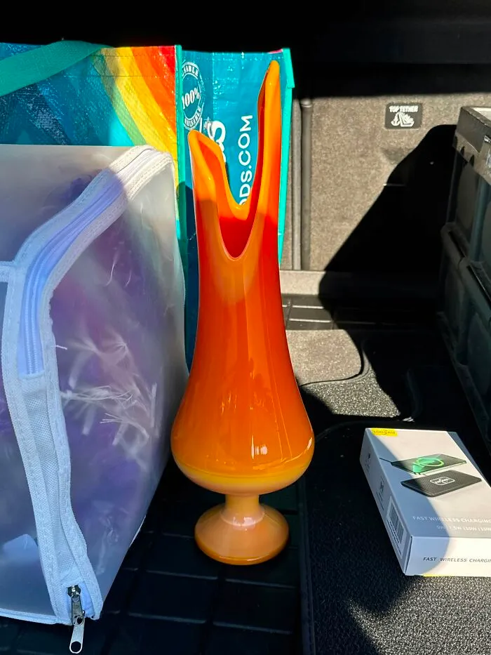 Bright orange and yellow swung glass vase as a unique thrift find in a car trunk