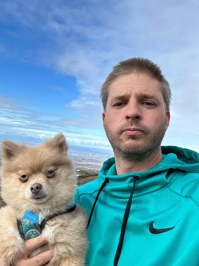 A man in a turquoise hoodie and his pomeranian look alike, showing pets that look like their owners