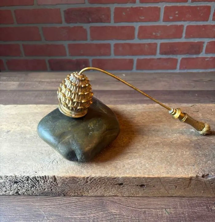 Antique brass candle snuffer with ornate handle on wooden table thrift store find
