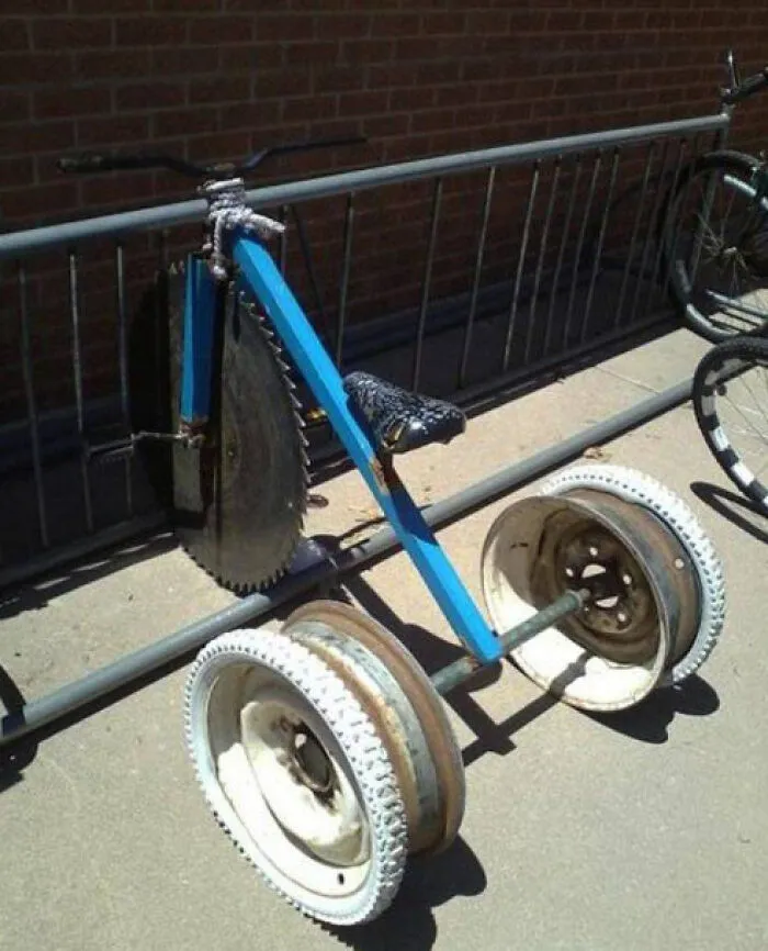 Handmade tricycle with saw blade front wheel demonstrating unhinged Slavic engineering.