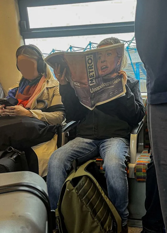 A commuter reading Metro newspaper creating a perfectly confusing photo optical illusion of a woman face.
