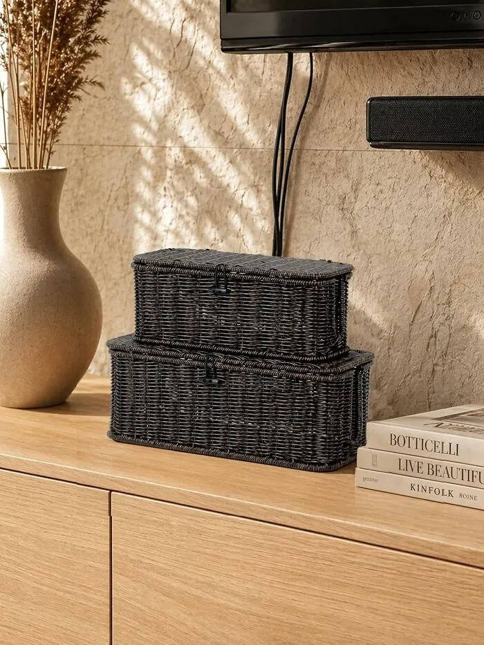 Two stylish woven storage baskets stacked on a wooden console table.