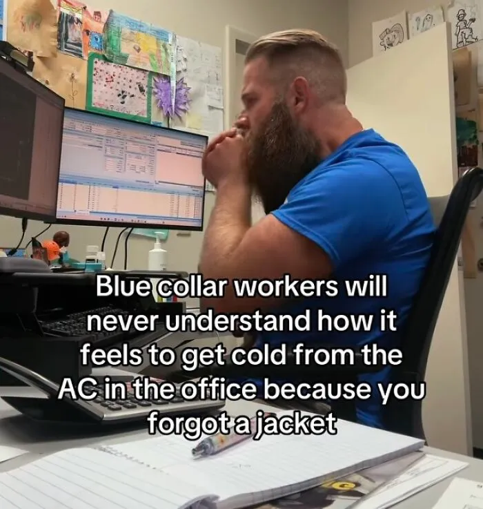 Man at desk cold from office air conditioning with text about blue collar workers and financial dystopia