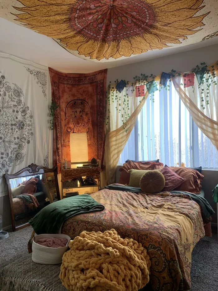 Cosy bohemian bedroom with sunflower tapestry and warm tones after a home makeover.