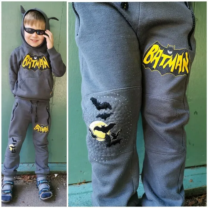 A young boy wearing a patched Batman hoodie and pants, demonstrating how creativity can save money.