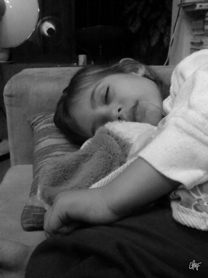 Black and white photo of a child sleeping on a couch taken with iPhone