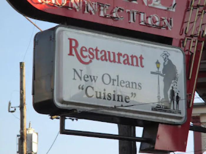 Restaurant outdoor sign misusing quotation marks around the word Cuisine.