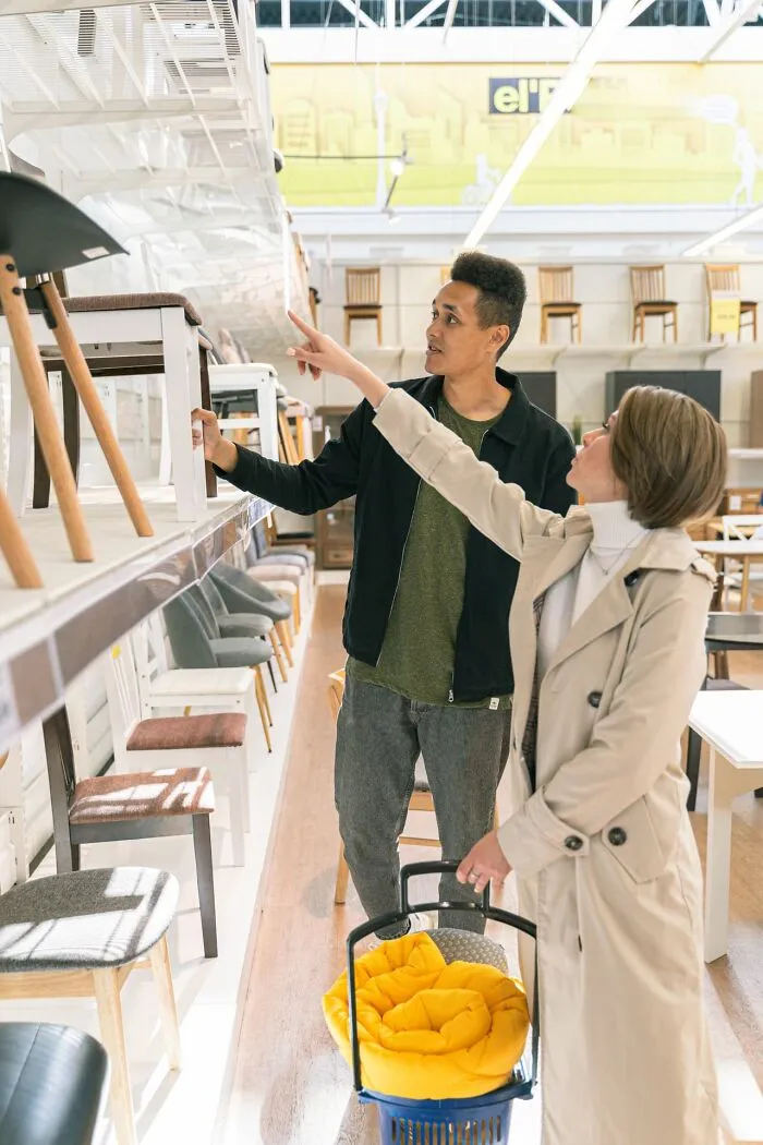 Couple shopping for chairs in store casually admitting disturbing things