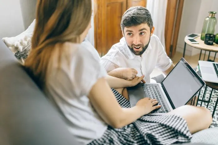 Man and woman discussing seriously disturbing things while using laptop at home