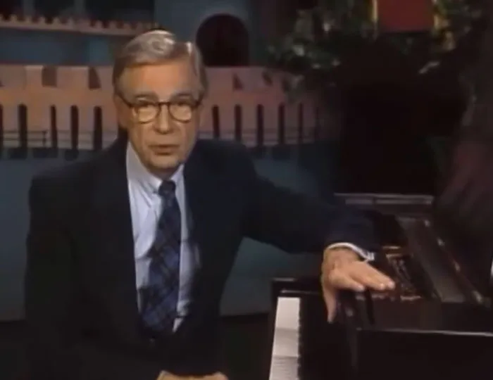 Mister Rogers seated at a piano during a TV appearance in 2001