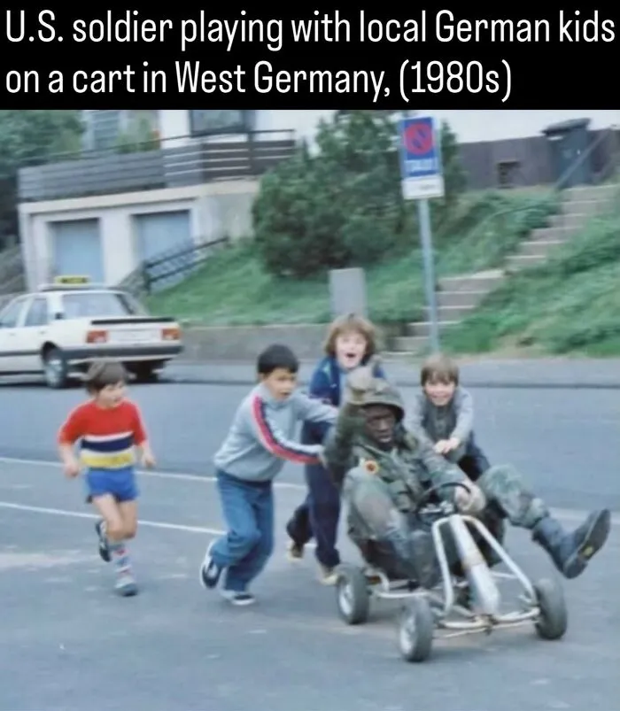 A US soldier playing on a go-kart with German kids in 1980s fascinating photos about history.