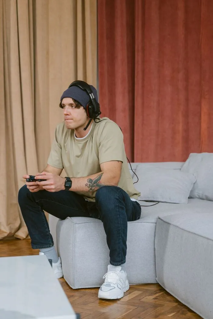 Man playing video games alone on the sofa, oblivious to problems leading his spouse to choose divorce