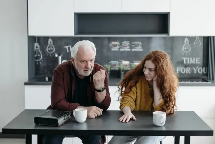 Older man and young woman having a serious disturbing things conversation over coffee