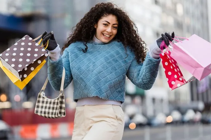 Smiling woman carrying multiple shopping bags, reflecting life after deciding to choose divorce