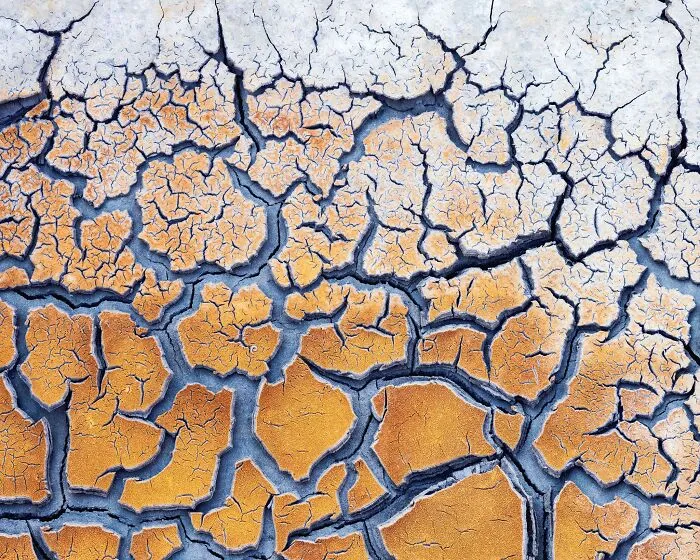 Detailed close-up of cracked, dry earth showing intricate patterns in natural landscape photography.