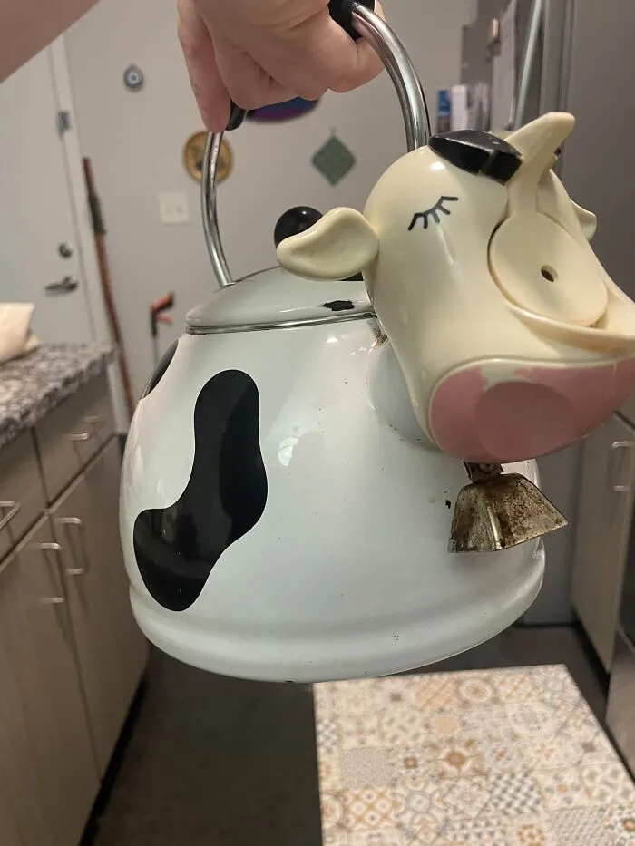 Quirky cow-shaped kettle found among thrift finds hanging in a kitchen