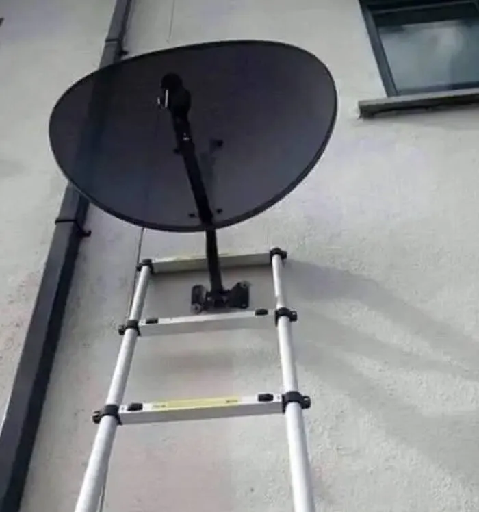 A satellite dish dangerously mounted to a ladder in a failed home improvement attempt.