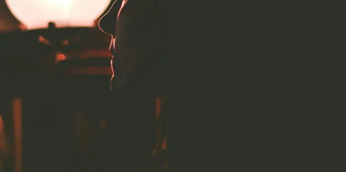 Side profile of a person dimly lit, capturing a mysterious tone for Halloween stories.
