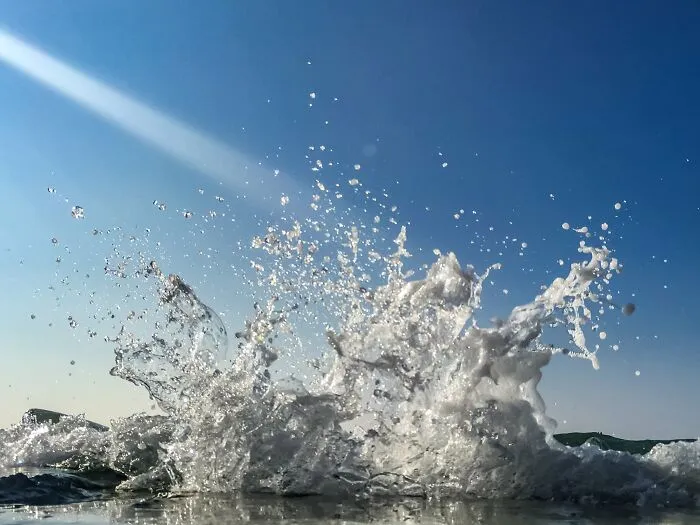 Water splash captured at the ocean shore with blue sky on iPhone