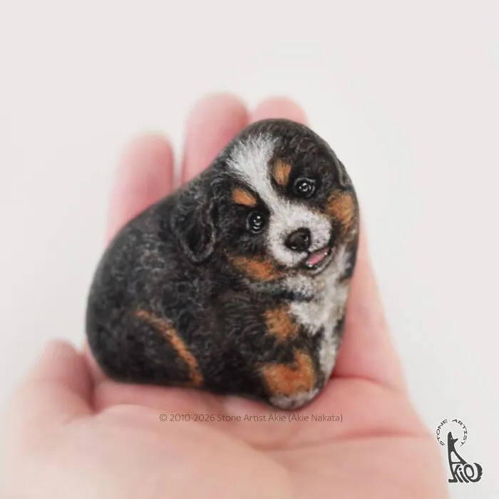 Detailed stone art of a small adorable dog held in hand