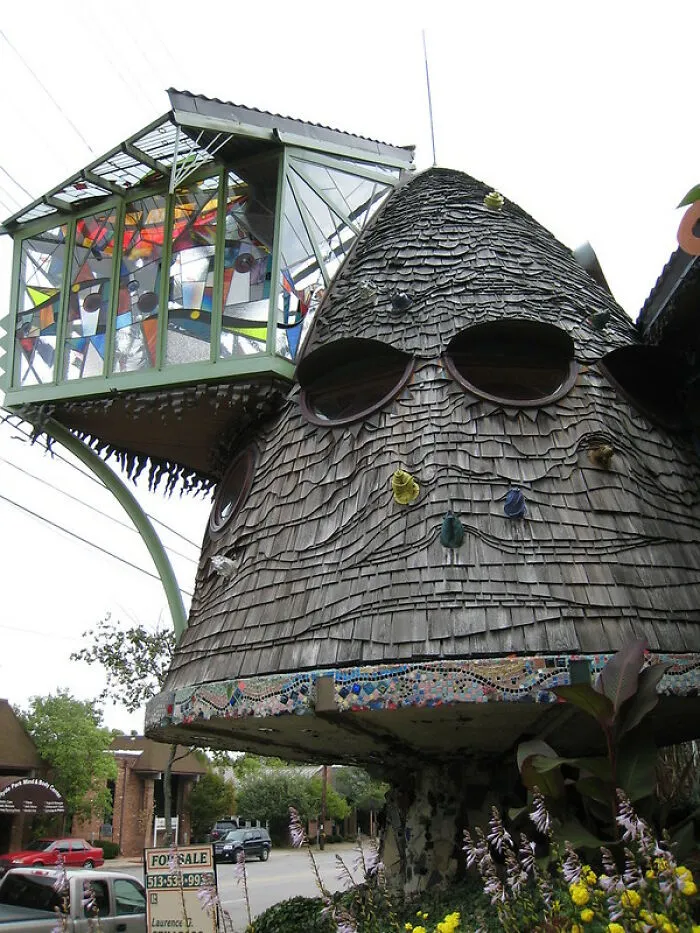 Weird strange building with a wooden shingle tower and colorful glass panels