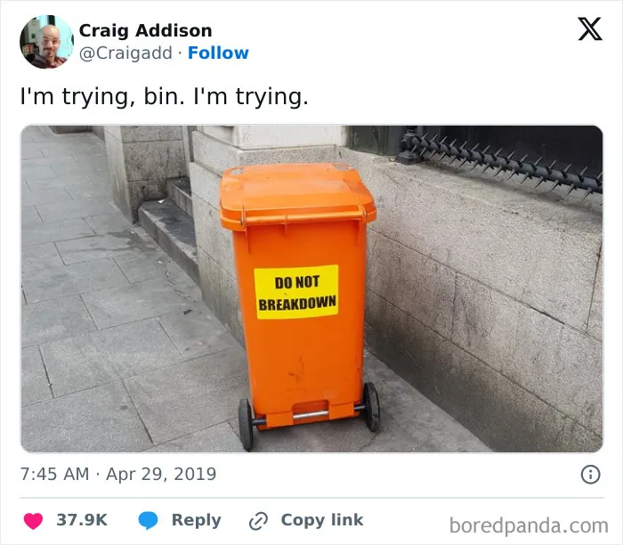 Orange trash bin with do not breakdown sign on city sidewalk