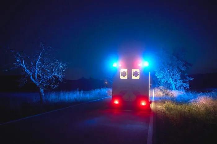 Ambulance with flashing emergency lights parked at night during funerals